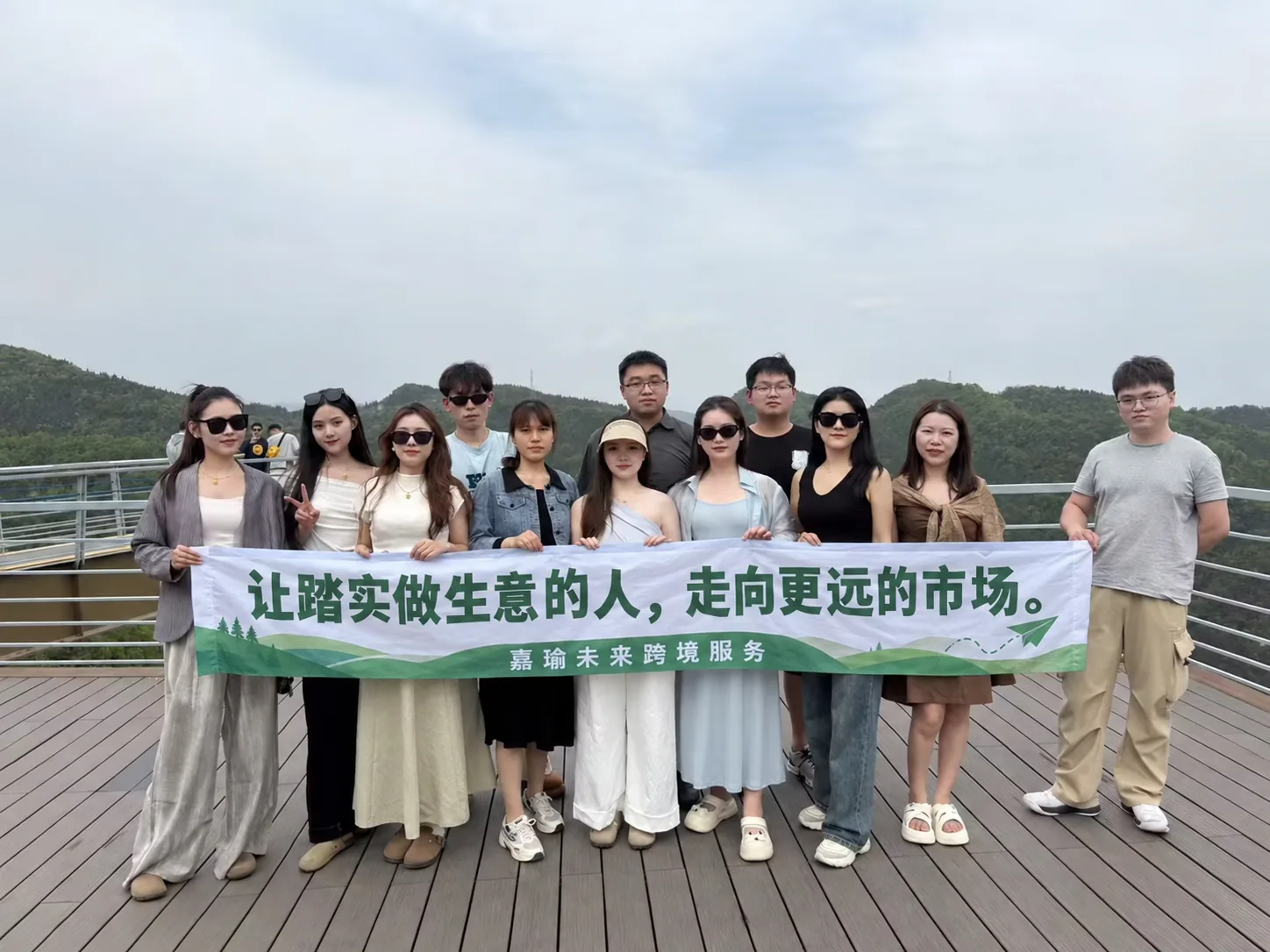 嘉瑜未来团队在山间合影并举起品牌标语